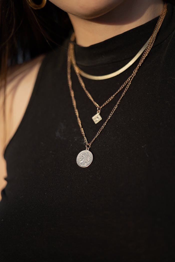 A woman wearing a necklace with a coin on it